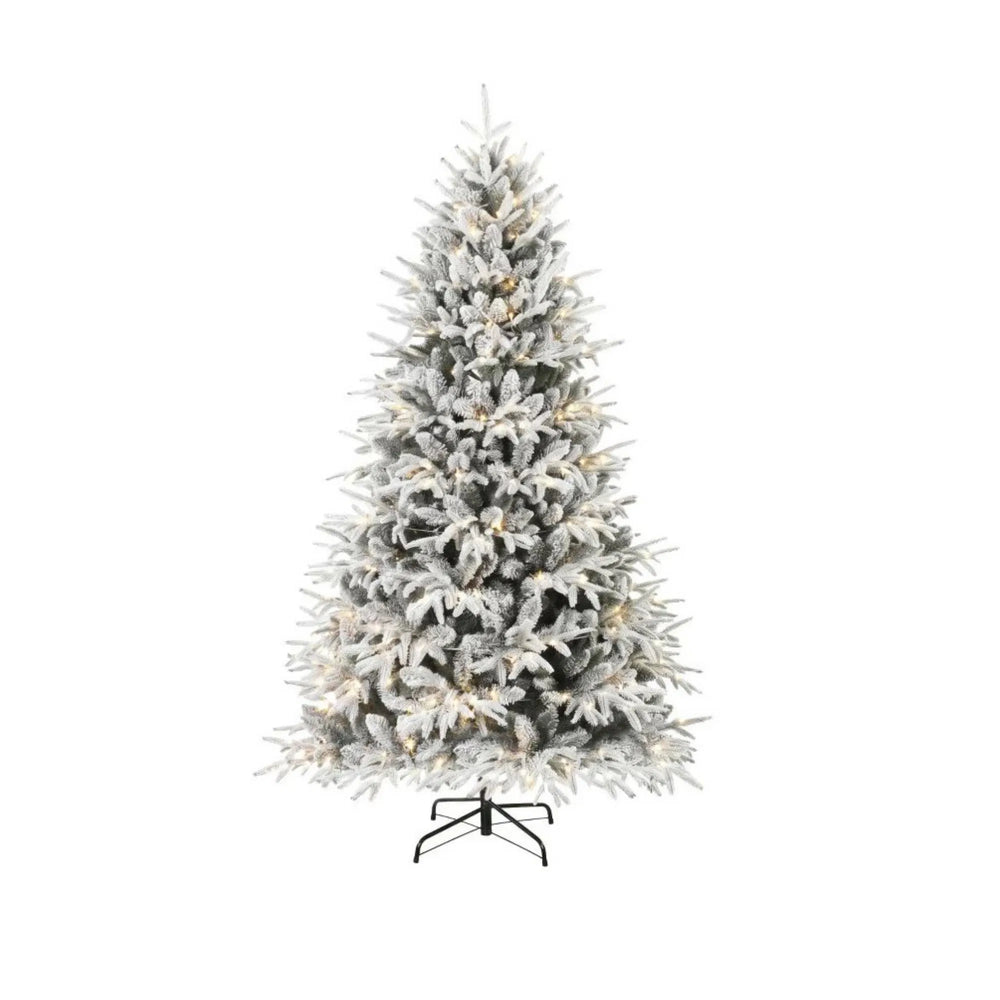 Fyldig snødekt juletre med varmhvite lys