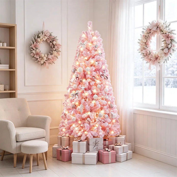 Lite rosa snødekt juletre med lys