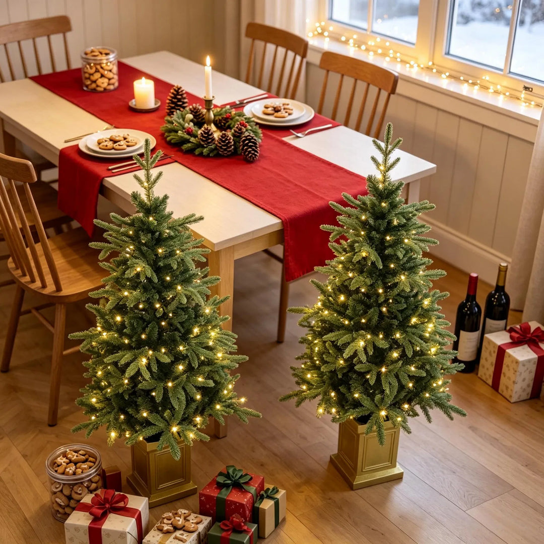 To juletrær i gullpotter med lys